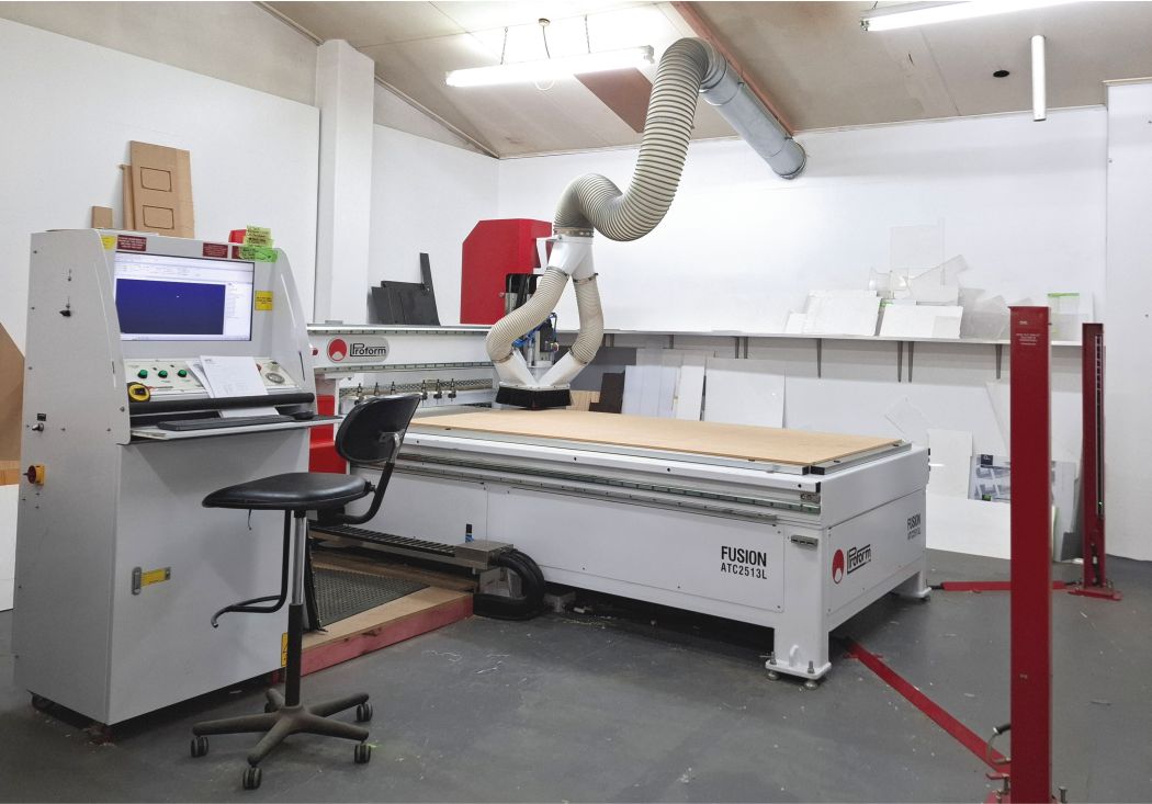 3 axis CNC machine with controls desk in a white workshop