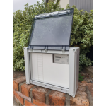 grey_temporary_power_box_with_lid_open_on_a_brick_retaining_wall