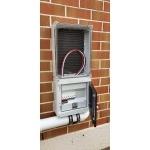 combined meter and distribution box on a brick wall outside with conduit for incomers