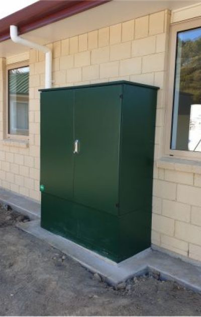green kiosk with large plinth against exterior wall