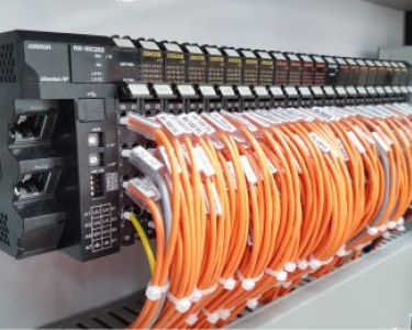 relay block wired with orange wires in a switchboard